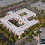 Aerial view of office complex with courtyards, surrounded by parking lots and trees. Modern architecture with white rooftops and landscaped pathways.